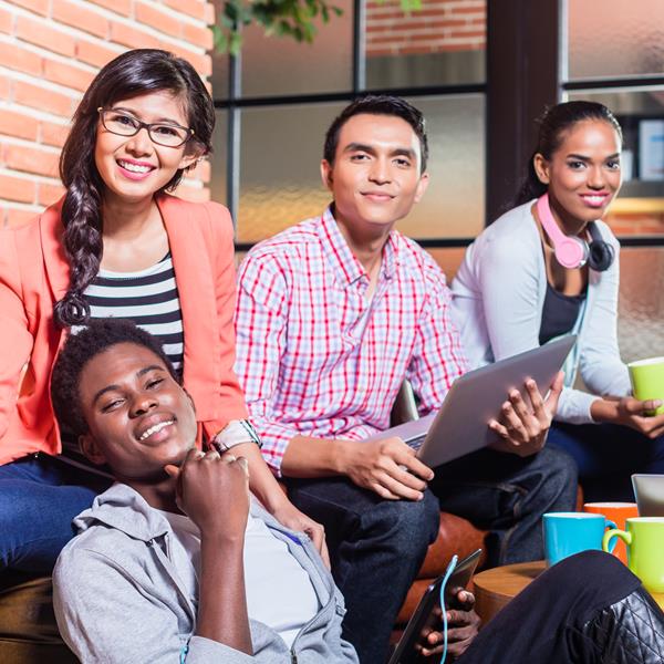 Group of five people at coffee house, smiling at camera