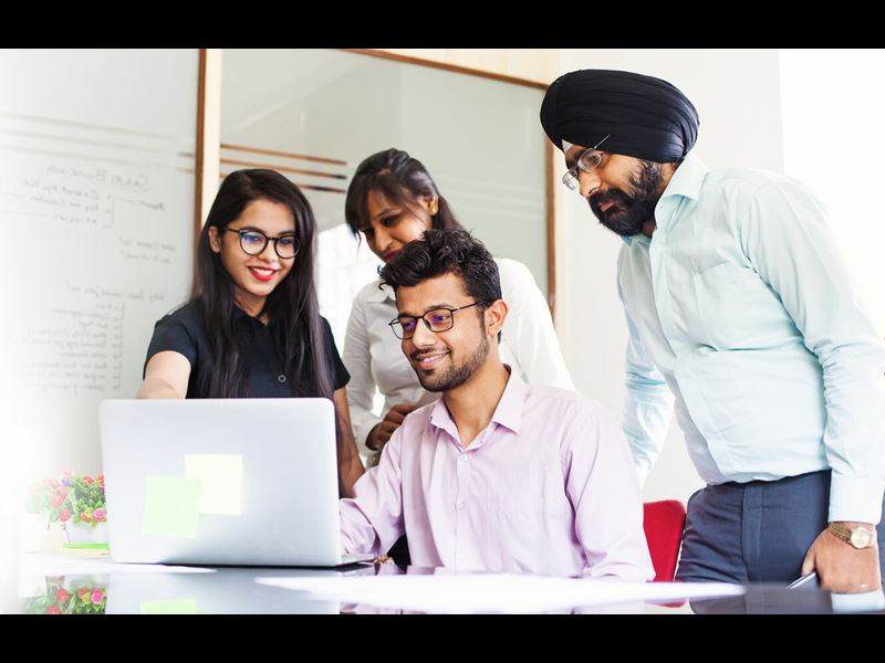 Team working together and looking on a screen of laptop