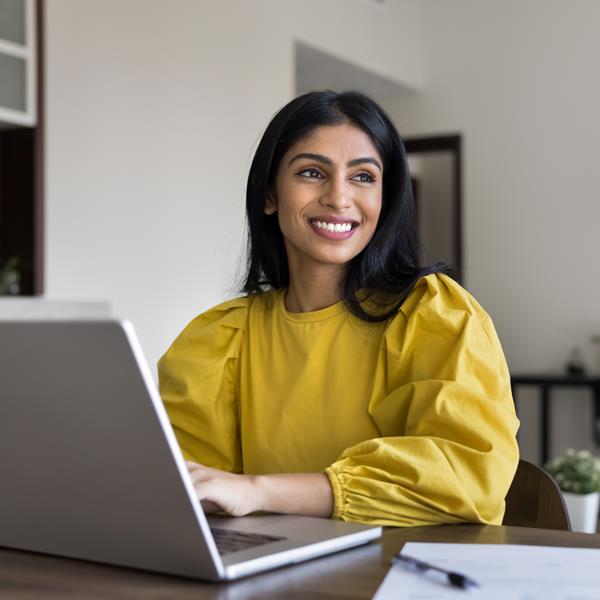 Woman Smiling While Working On Laptop