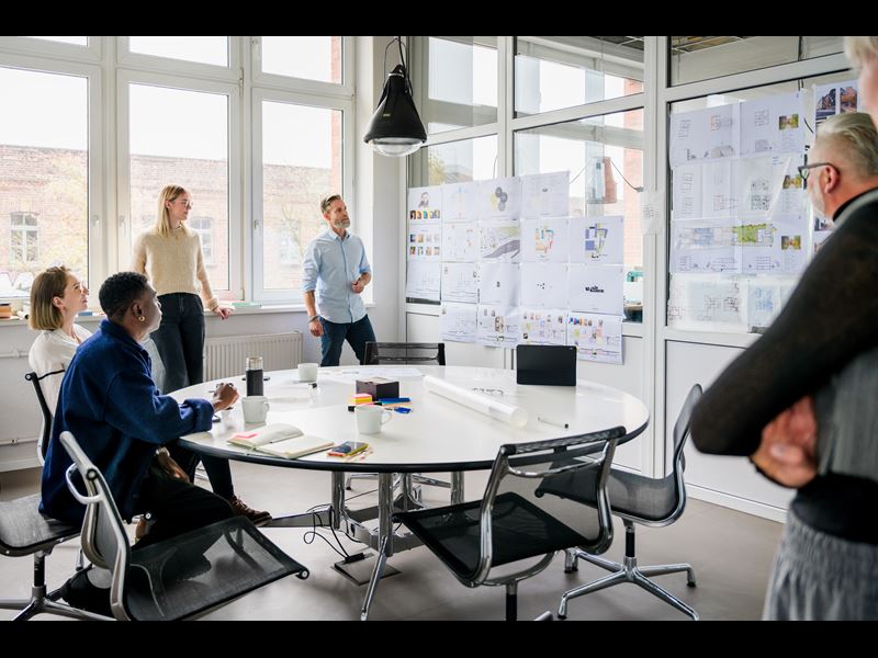 Group Of Diverse Professionals In A Meeting Room Looking At Charts