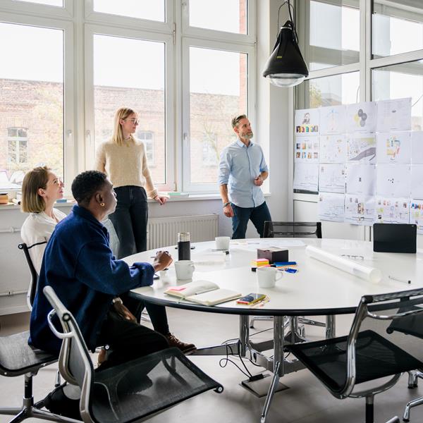 Group Of Diverse Professionals In A Meeting Room Looking At Charts
