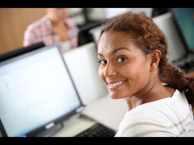 Woman working in office, smiling at camera