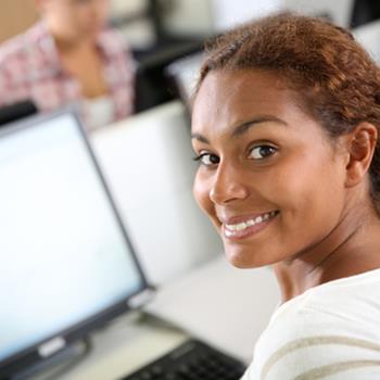 Woman working in office, smiling at camera