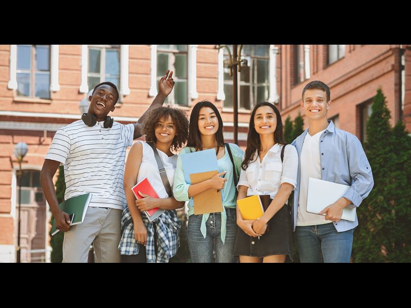 Five students standing together and smiling