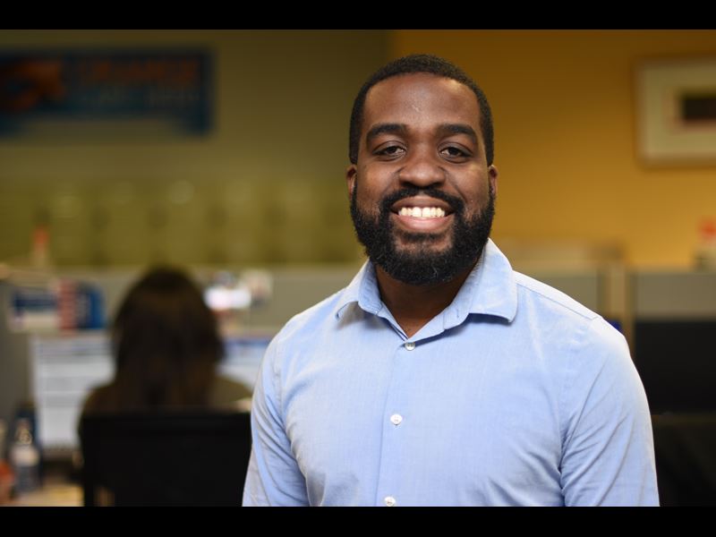 Assurant employee, Javoughn Anthony, smiling at camera while in office