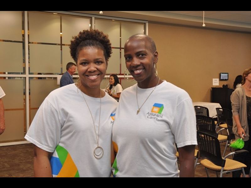 Two Assurant employees smiling at charity event
