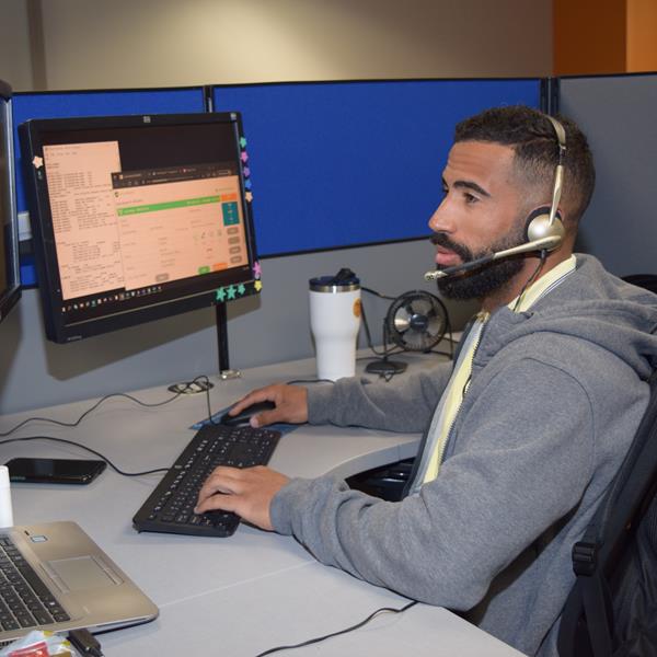 Assurant employee working from desk in office with headset on