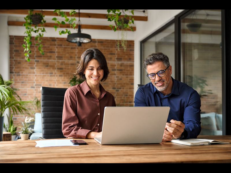 Assurant Blog Header Employees Working On Laptop