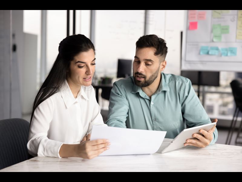 Young Employees Smiling And Looking At Documents (1)