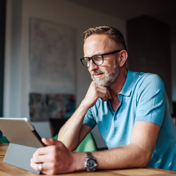 Mature Male Looking At Tablet