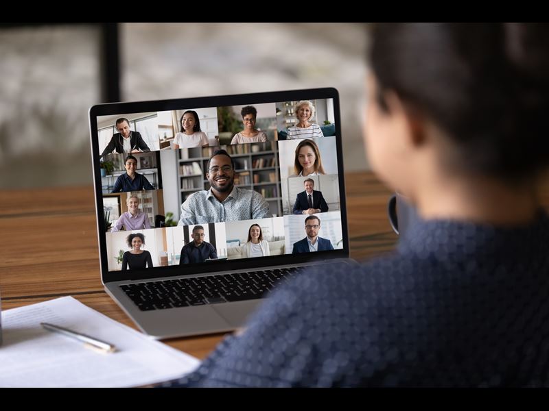 Woman talking on conference call with coworkers on video