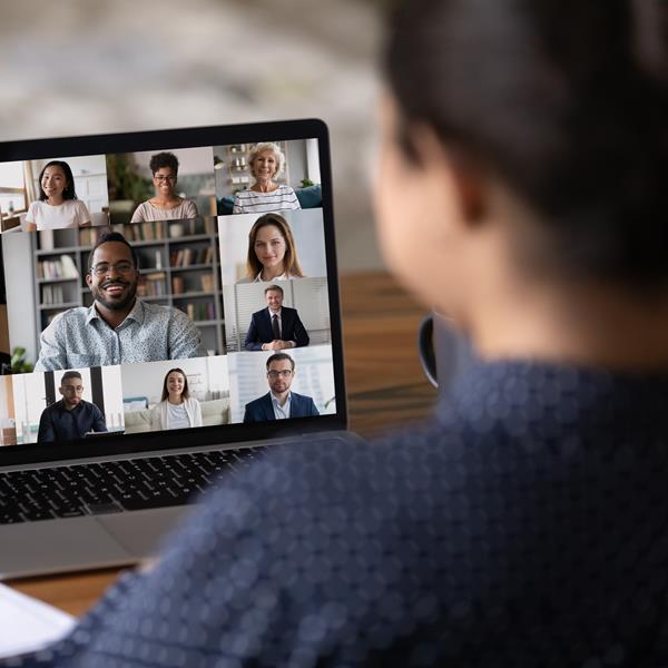 Woman talking on conference call with coworkers on video