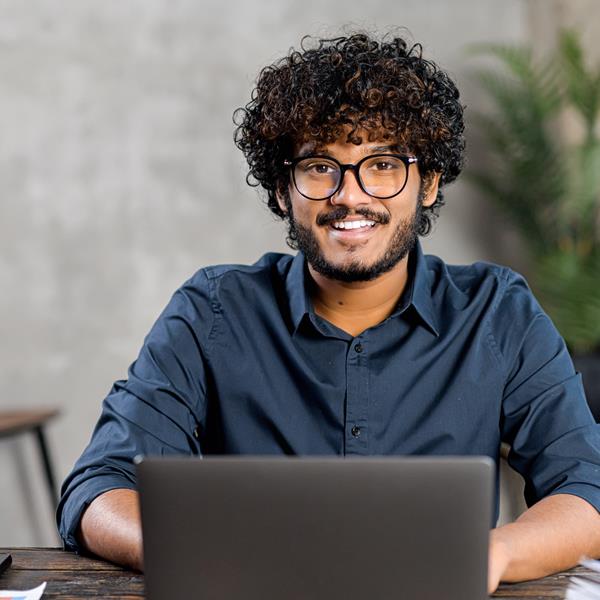 Young Man Smiling While On Laptop