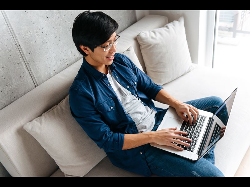 Man working on laptop from couch