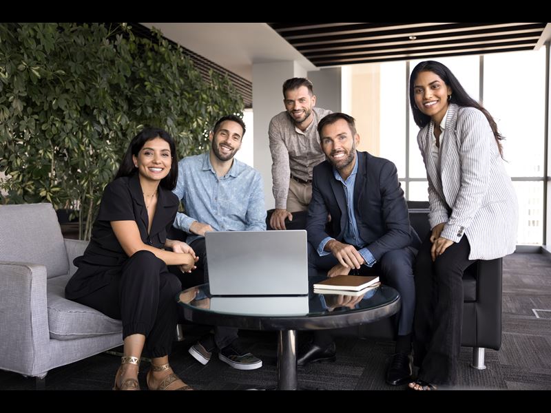 Employees Smiling In A Hybrid Work Setting