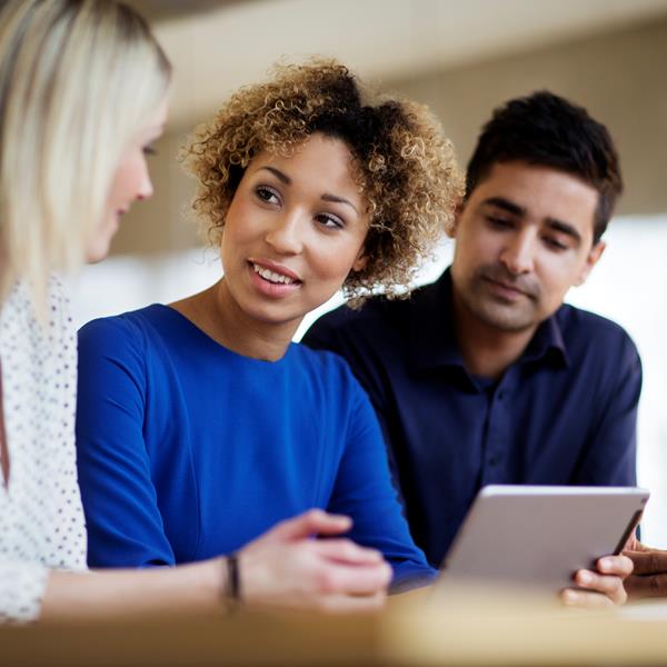 Three Professionals Talking And Holding Tablet