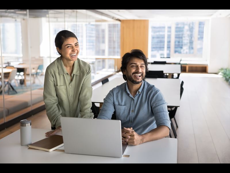 Two Employees Smiling And Collaborating
