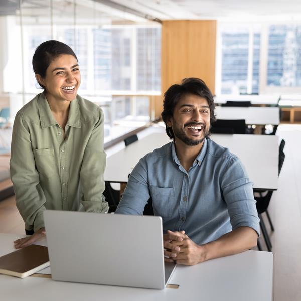 Two Employees Smiling And Collaborating