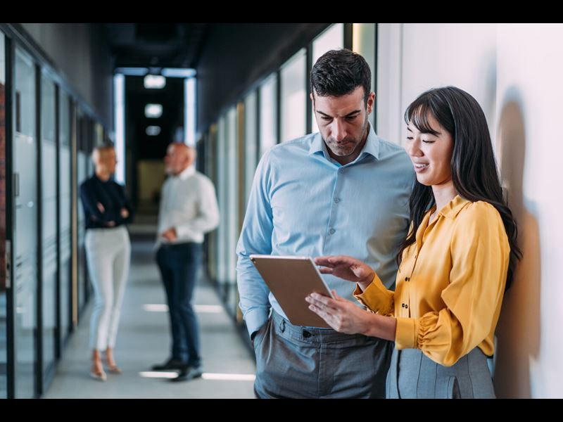 Two Coworkers Having A Discussion In Modern Office