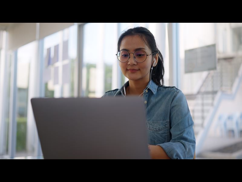 Woman Smiling And Working On Laptop