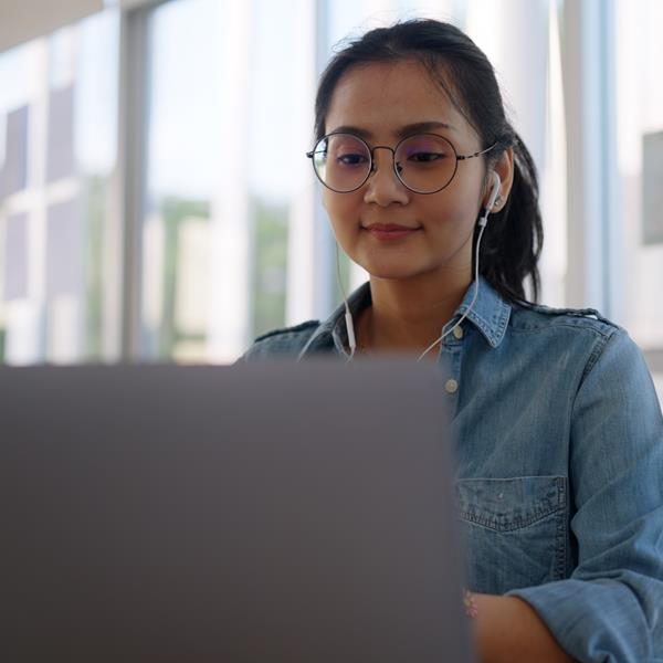 Woman Smiling And Working On Laptop