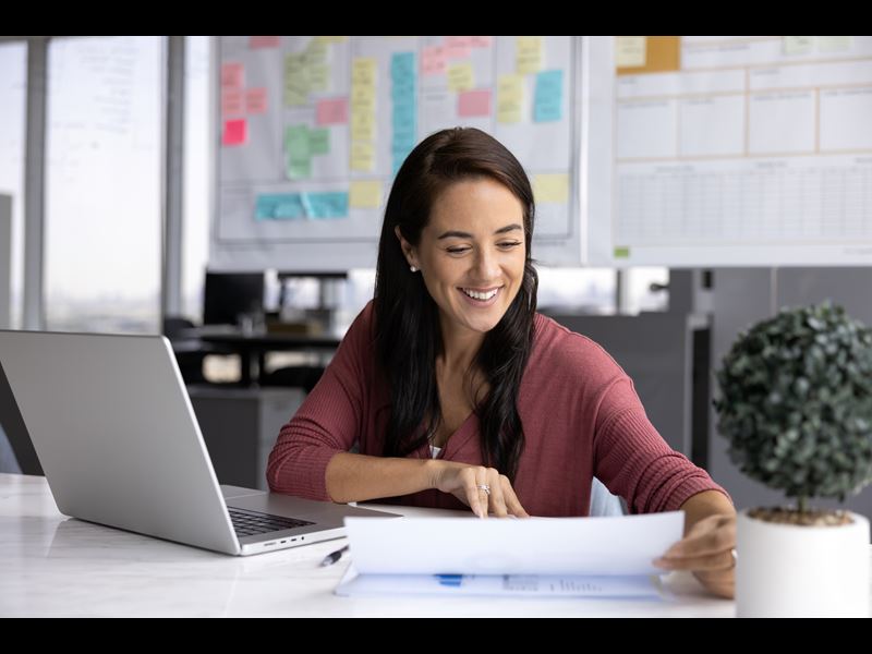 Woman Smiling And Looking At Papers
