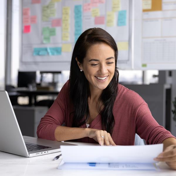 Woman Smiling And Looking At Papers