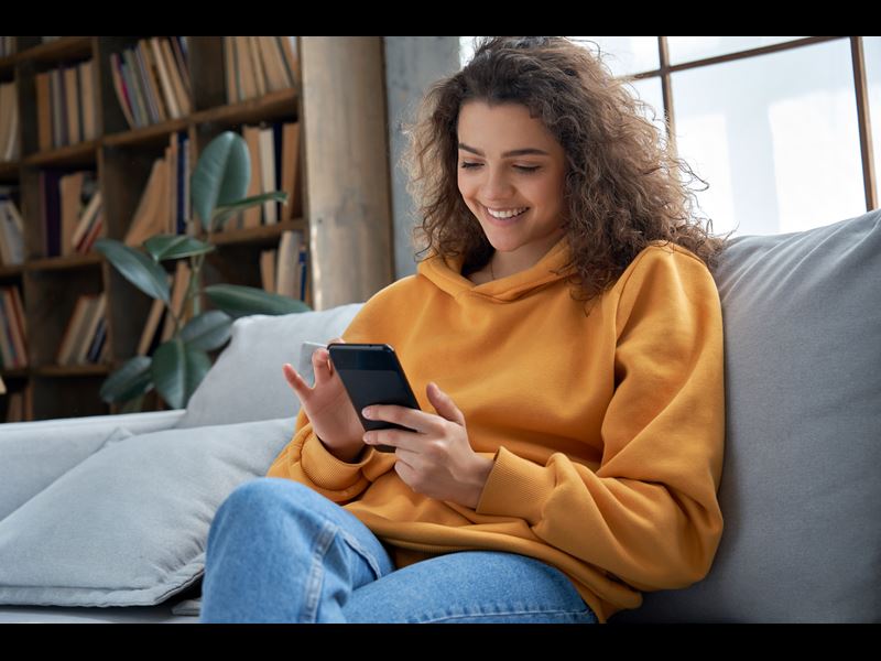 Woman using mobile device on couch