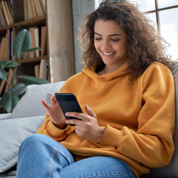 Woman using mobile device on couch