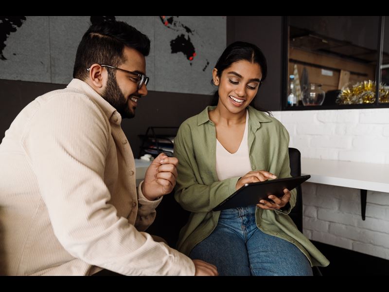 Assurant Blog Header Image Two Employees Collaborating Looking At Tablet