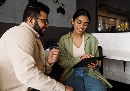 Assurant Blog Header Image Two Employees Collaborating Looking At Tablet