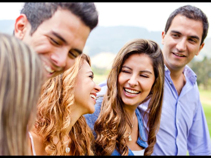 Five people smiling and looking at each other