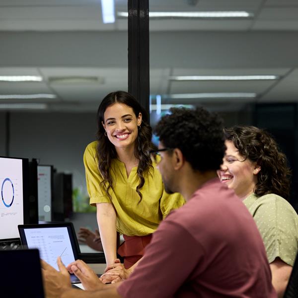 Group Of Professinals Smiling And Working On Laptop And Tablet