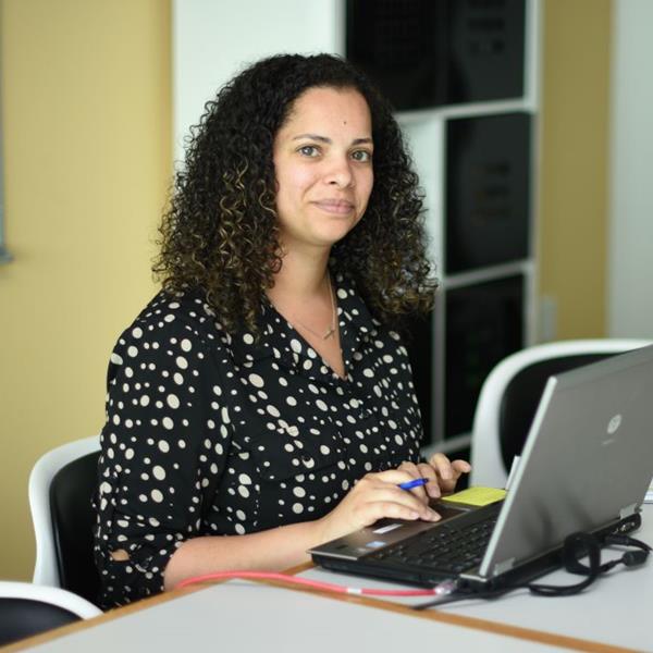 Assurant employee, Patty Serrano, smiling at camera while working in office
