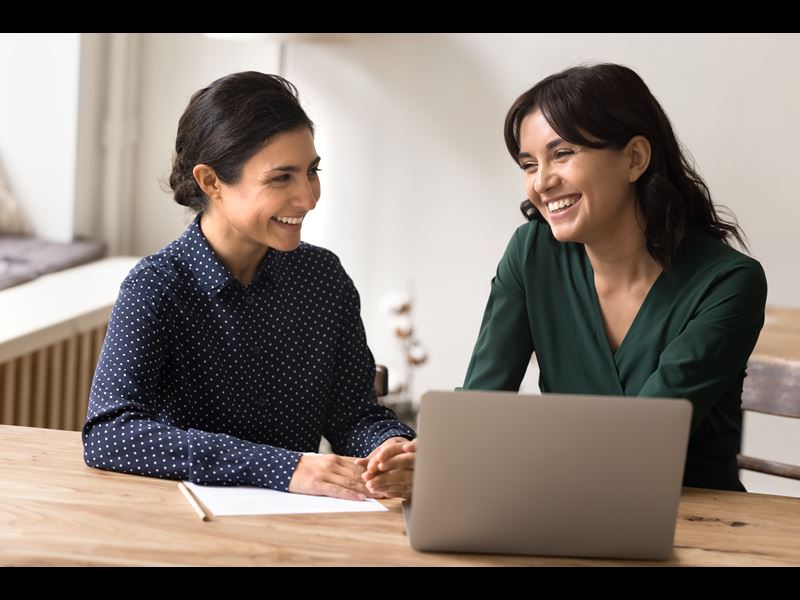 Two Female Employees Smiling With Laptop