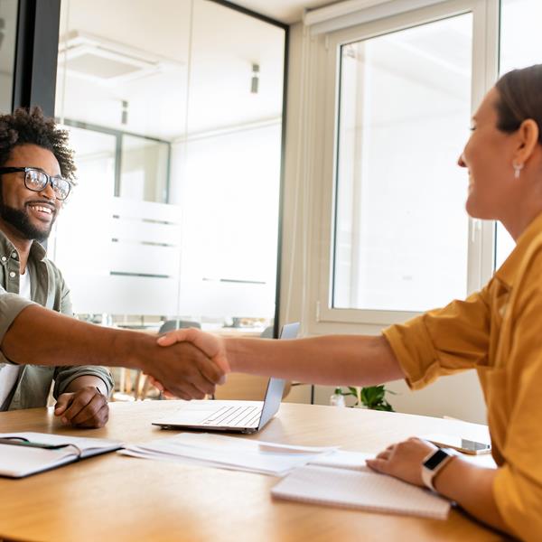 Man and woman shaking hands over table