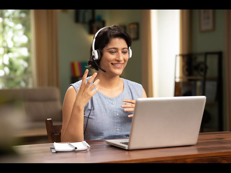 Woman With Headset Talking On Laptop