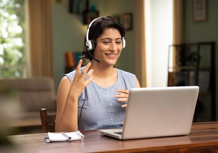 Woman With Headset Talking On Laptop
