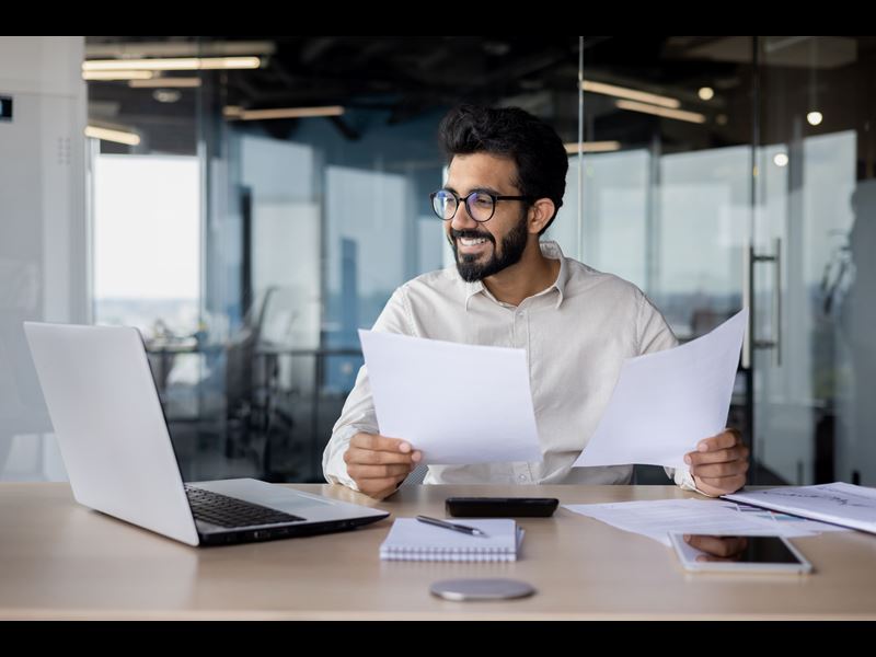 Man Smiling While Holding Papers