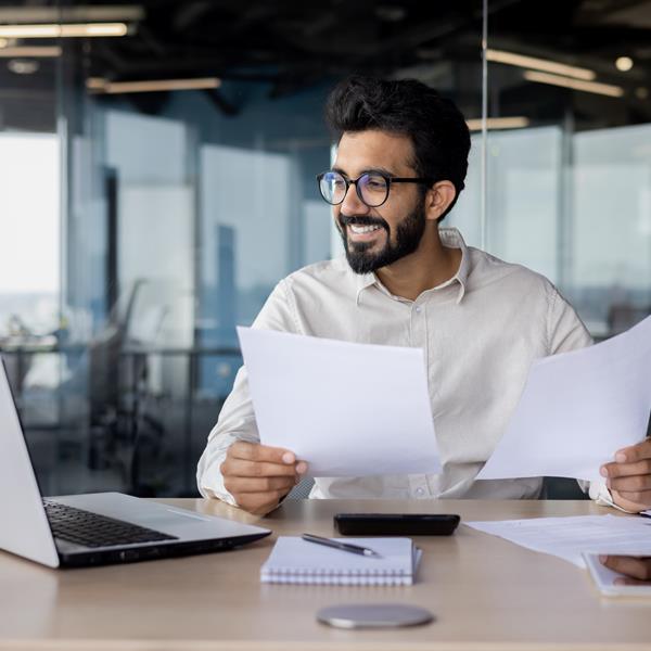 Man Smiling While Holding Papers