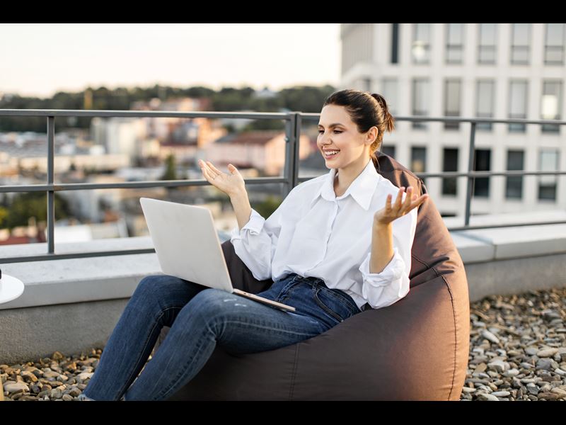 Woman Smiling While Working Outside On Laptop