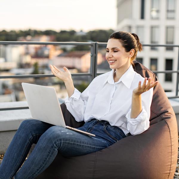 Woman Smiling While Working Outside On Laptop