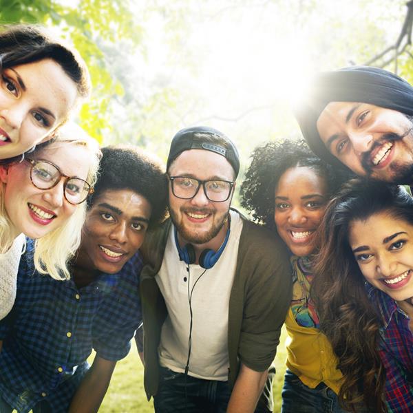 Diverse group of seven people, standing together and smiling at camera