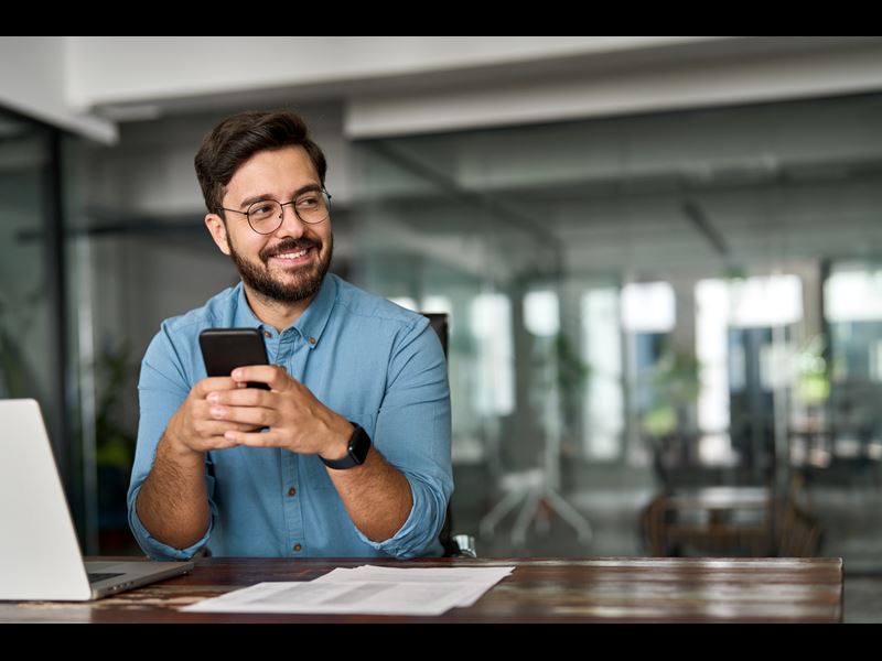 Male Employee Smiling Holding Phone