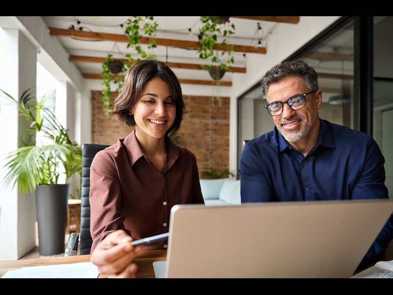 Two Employees Working On Laptop